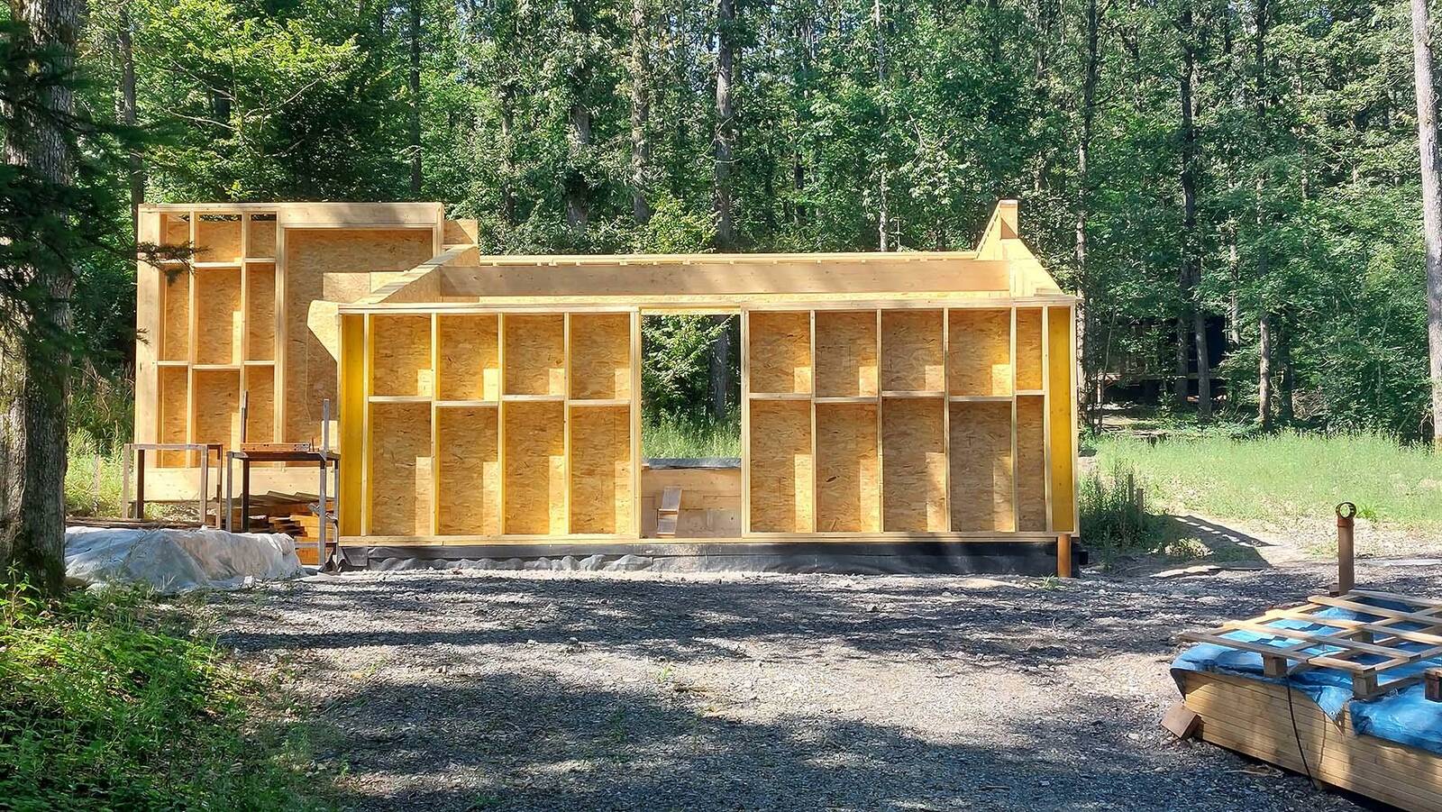 Mini‑maison en bois dans la forêt à Philippeville – vue extérieure Chantier de construction d’une mini‑maison en bois à Philippeville Structure bois de la mini‑maison – détail constructif Intégration de la mini‑maison dans la forêt – Philippeville Détail de façade en bois – mini‑maison Philippeville Vue du volume compact de la mini‑maison en forêt Mini‑maison en bois en cours de construction – Wallonie Implantation de la mini‑maison dans le paysage forestier