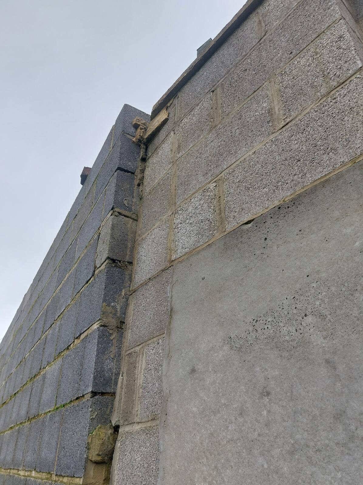 Déplacement du mur causé par la pression des terres retenues. observée lors d’une visite avant achat à Liège, identifiée par un architecte.