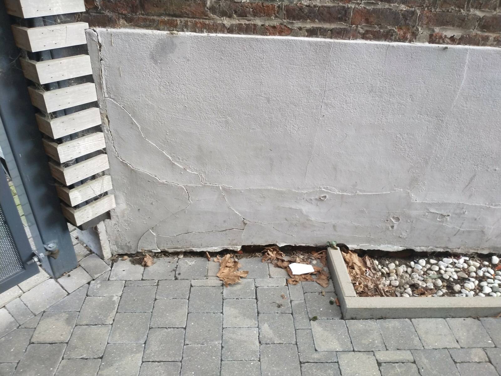 Humidité en pied de mur contre terre due à un cimentage incomplet et à l’absence d’étanchéité en mur de cave, défaut constaté lors d’une expertise à Waremme.
